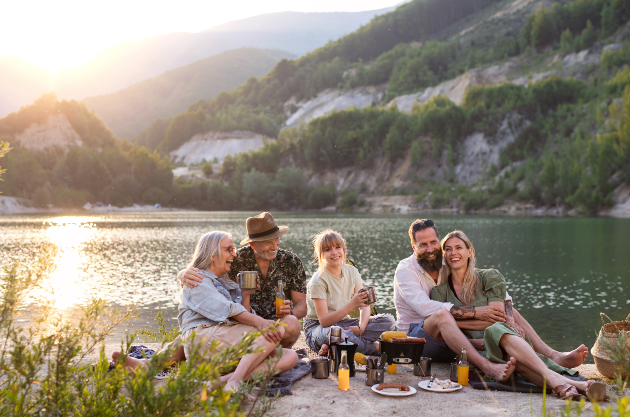 Image of happy family of grandparents, in-law and grand daughter relaxing and having a good time by the lake